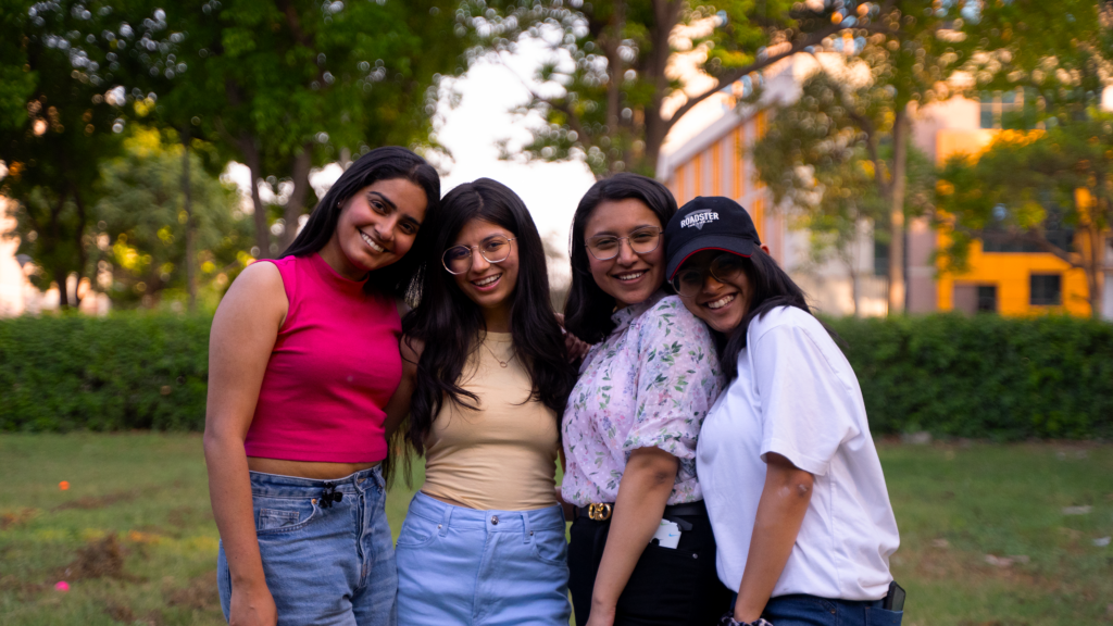 A group of four friends happily posing outdoors, capturing a moment of joy and friendship.