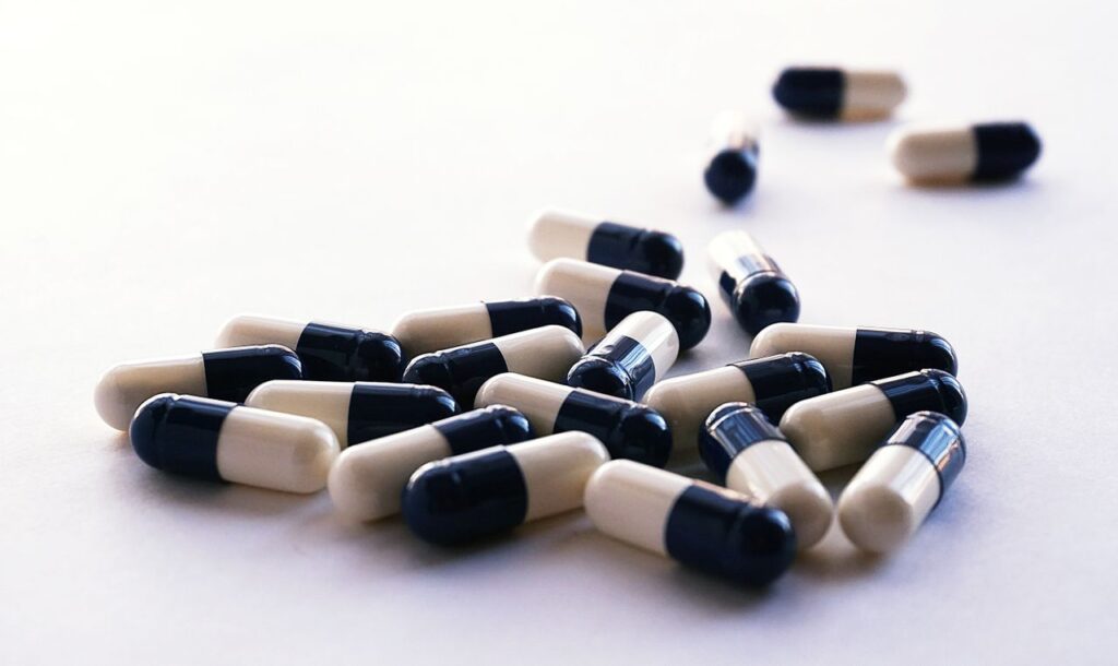 Assorted capsules scattered on a white surface. Healthcare and medicine concept image.